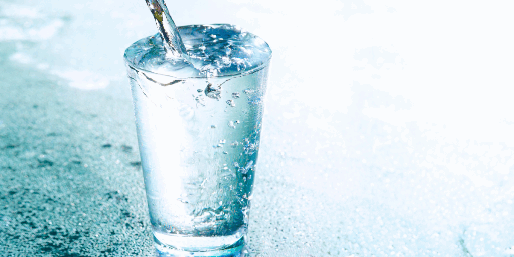 Un verre d'eau est rempli jusqu'à ras-bord.